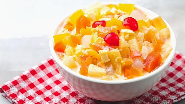 Filipino fruit salad in a white bowl on a red checkered napkin