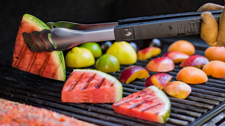 grilling some fruits, including watermelon, lemons, and peaches