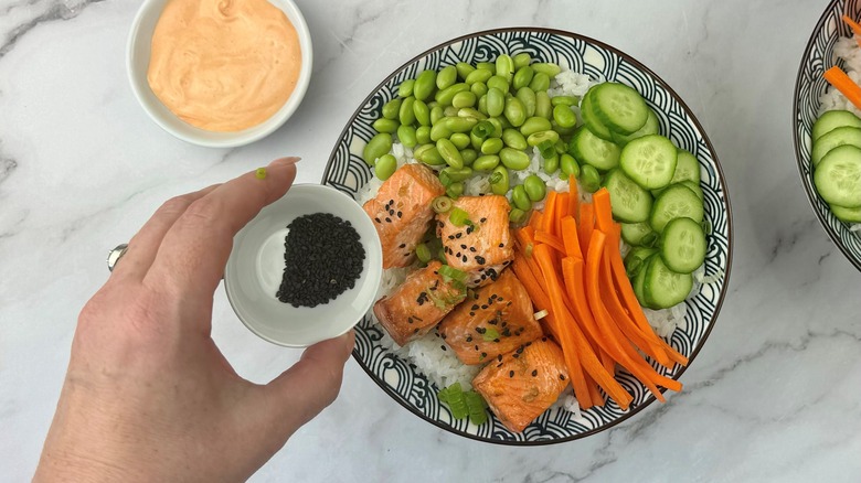 hand holding seeds above bowl