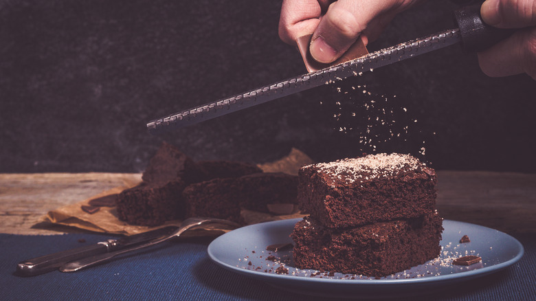 Zesting chocolate flakes on brownies