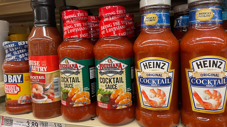 Jars of different brands of red cocktail sauce on a supermarket shelf