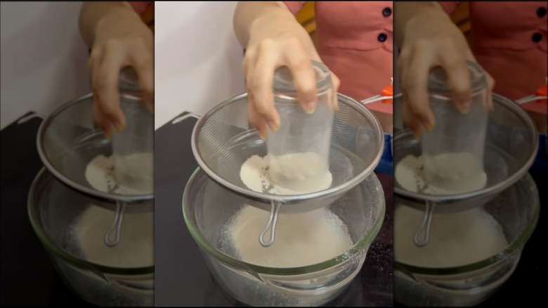 Sifting flour with glass and sieve