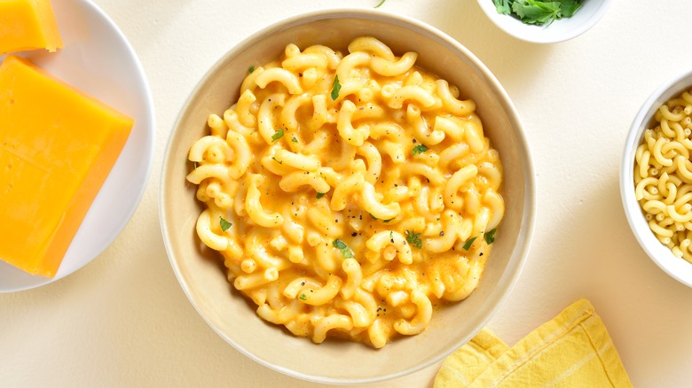 Bowl of cooked boxed mac and cheese next to ingredients