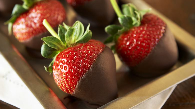 chocolate covered strawberries on a gold tray