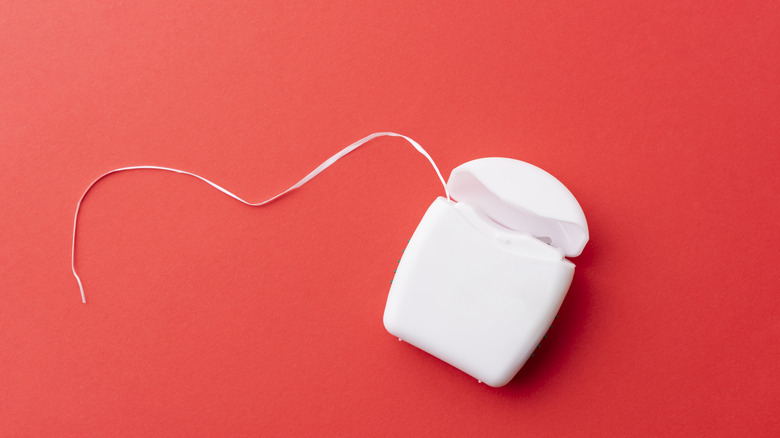 Dental floss container red background