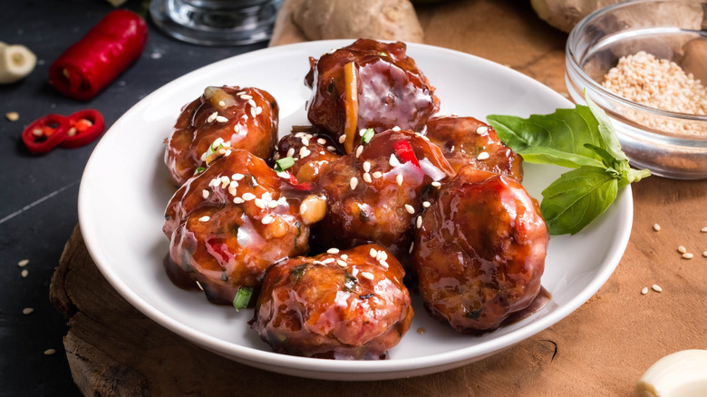 Sweet and spicy meatballs on white plate covered in glaze