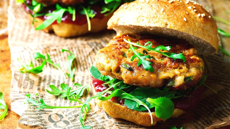 Open-faced turkey burger on a sesame seed bun with raw greens