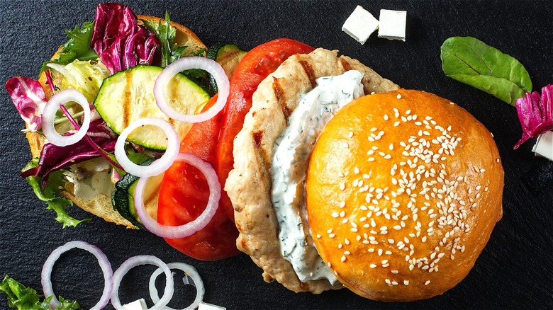 Deconstructed turkey burger with roasted vegetables and a creamy herb sauce