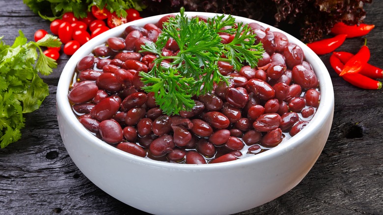 a bowl of red kidney beans on a wooden table