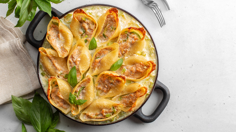 Jumbo pasta shells stuffed with fish in creamy white cheese sauce