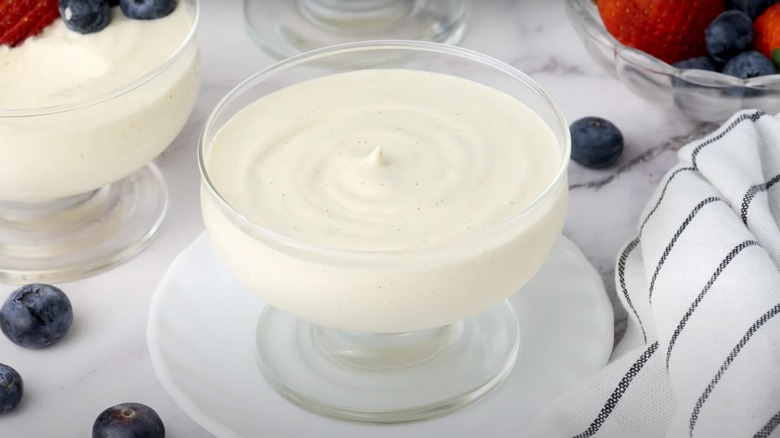 Vanilla bean mousse in cup surrounded by berries