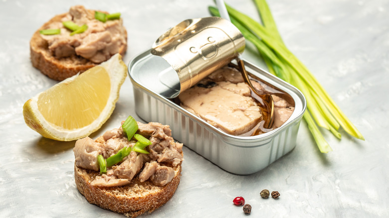 Canned fish in a tin and on an open face sandwich