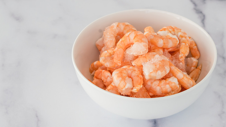 frozen shrimp in bowl on marble countertop