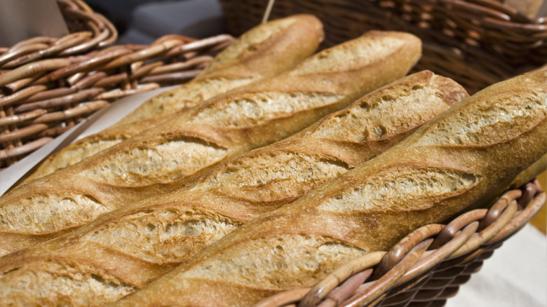 A basket full of baked baguettes