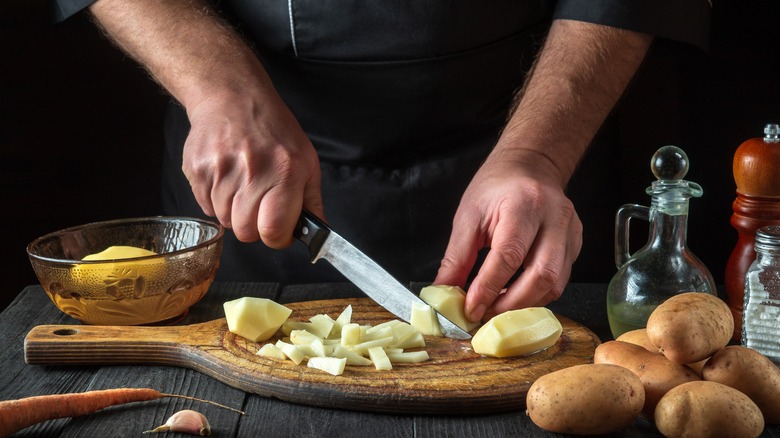 Chef chopping potatoes