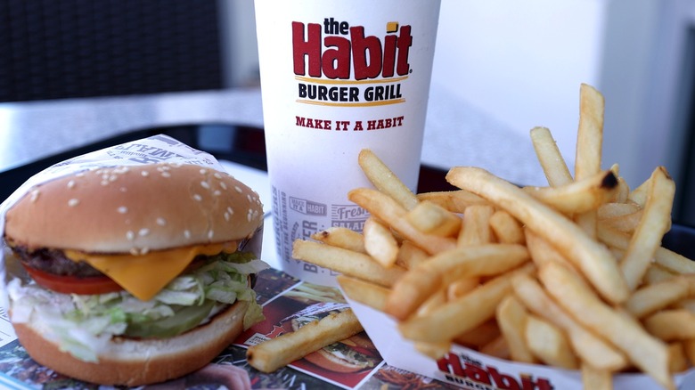 A Habit Burger Charburger, french fries, and a soda sit on a restaurant tray