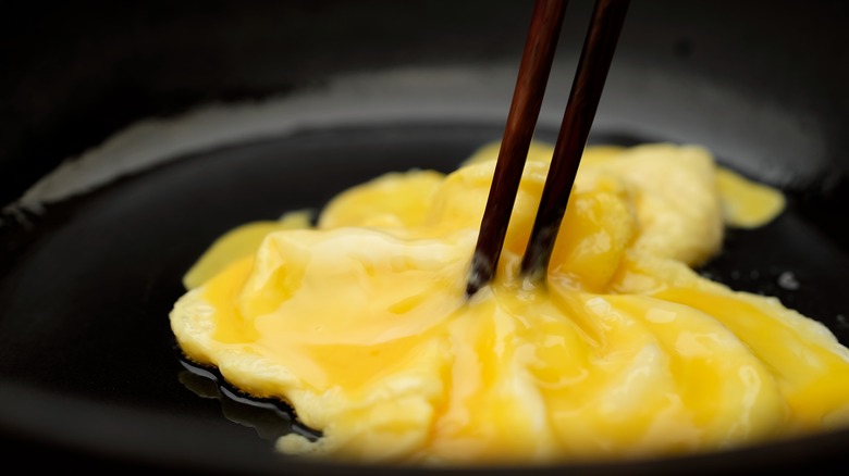 Chopsticks stirring scrambled eggs