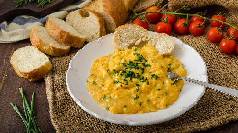 French-style scrambled eggs with chives and bread slices