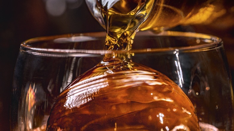 Whiskey poured over cylindrical ice