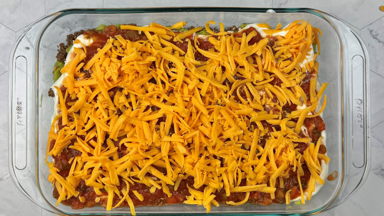 Grated cheddar cheese layered in large baking dish