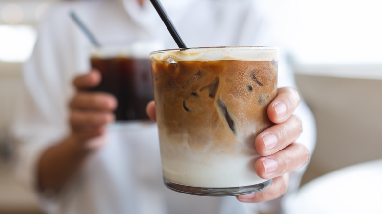 Woman holding iced coffee drinks 