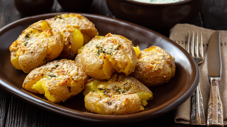 crispy smashed potatoes with Parmesan in brown dish