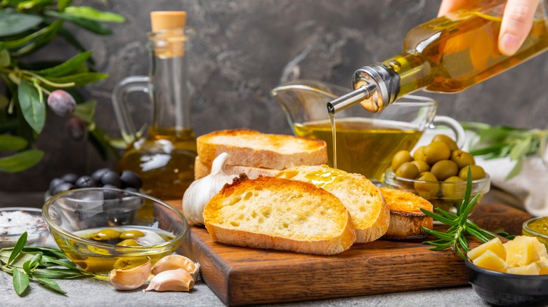 Toasted bread drizzled with olive oil on cutting board