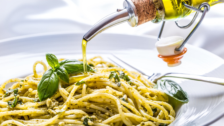 putting olive oil on pasta
