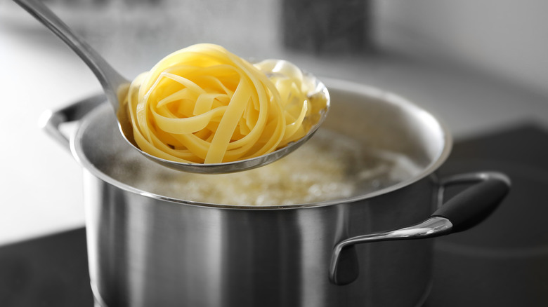 Using pasta spider or strainer to remove pasta from pan of water