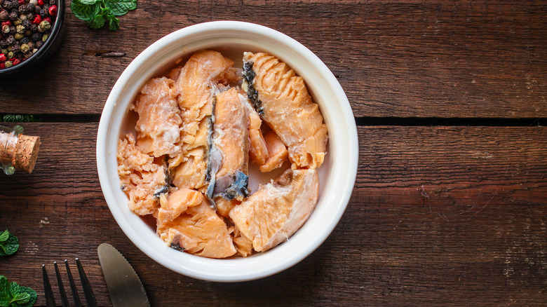 Canned salmon in white bowl on table