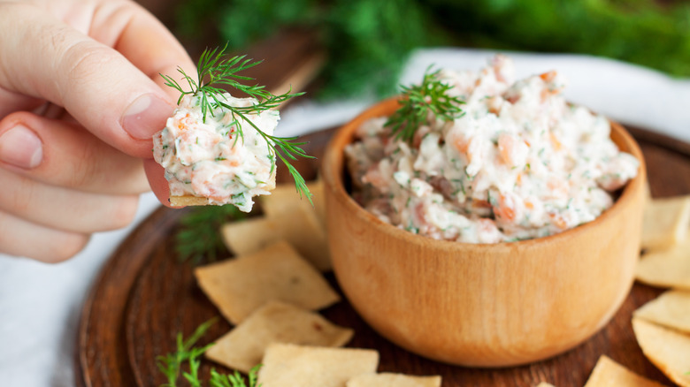 Salmon dip in a wooden bowl with crackers