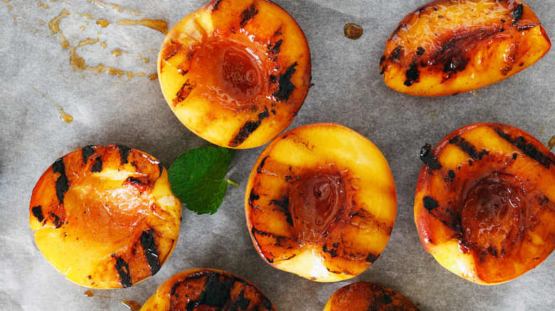 Slices of grilled peaches with mint leaves