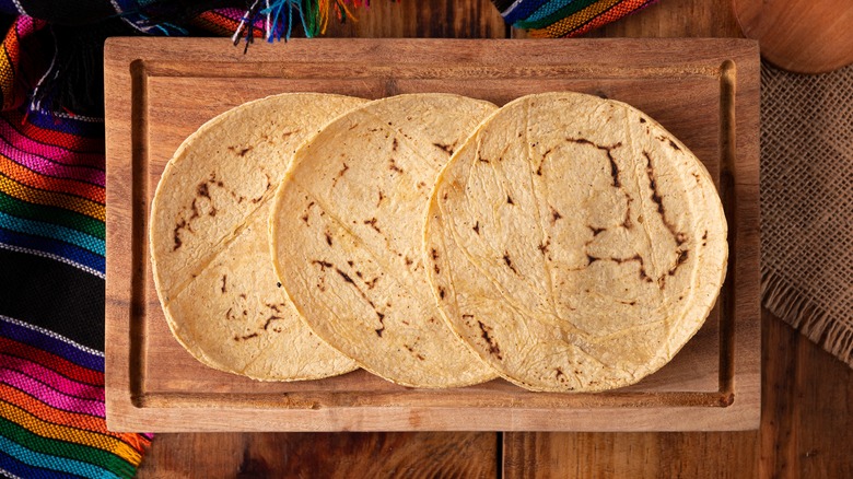 Three flour tortillas on wooden platter