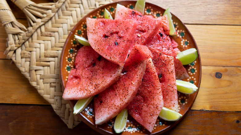 Watermelon topped with chili powder and limes