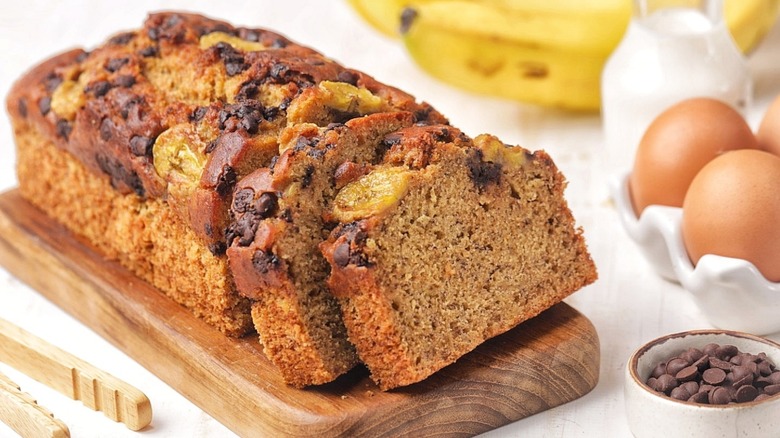 sliced loaf of banana bread on a wooden slab