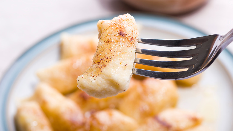 Cinnamon dusted gnocchi picked up with fork