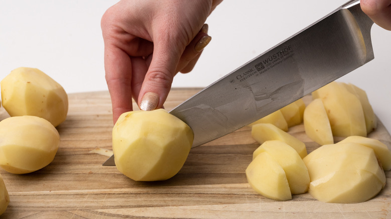 slicing peeled potatoes 