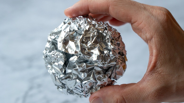 Hand holding ball of tinfoil