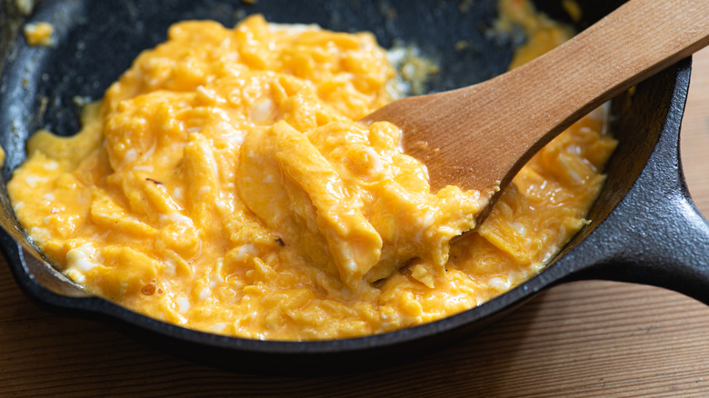 Cooking scrambled eggs in a skillet with a spatula
