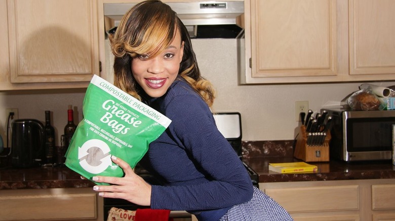 Founder of Grease Bags holding the product in a kitchen