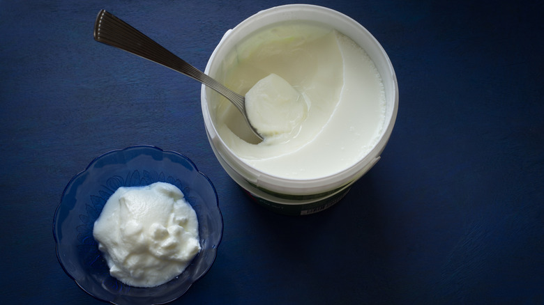 Plain yogurt in a tub and bowl