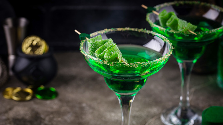 Gorgeous emerald green cocktails with sour candy garnishes are ready to be consumed