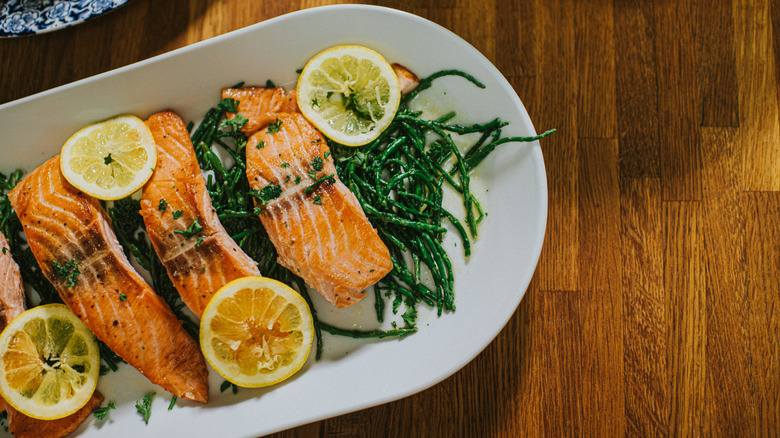 Grilled salmon on a bed of asparagus, topped with lemon slices