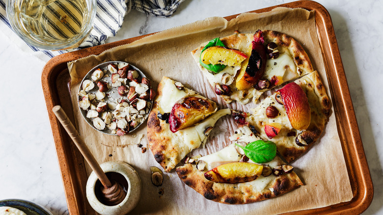 Flatbread on baking sheet with wine and toppings