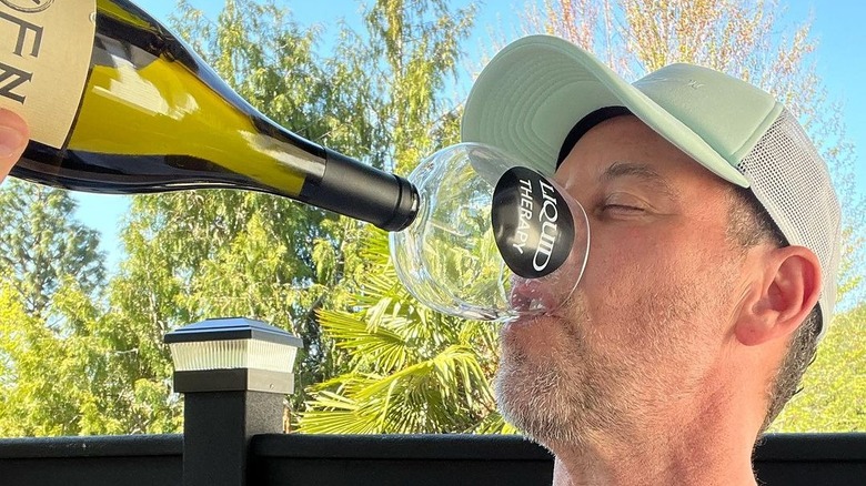 owner chugging from bottle of wine