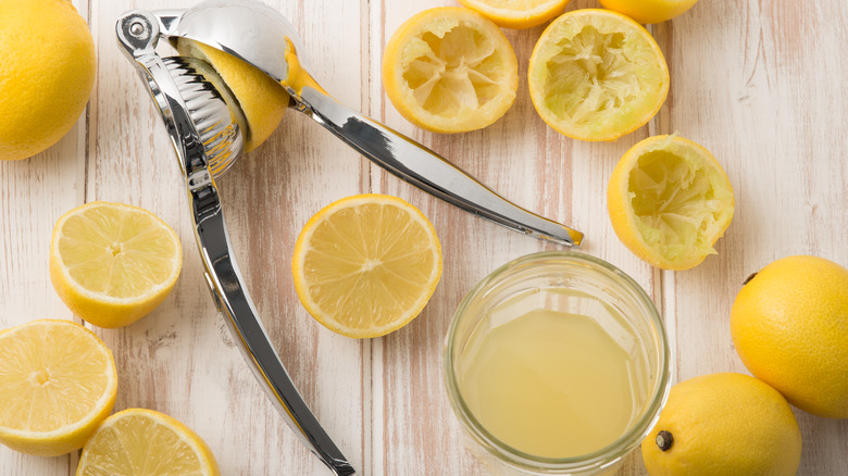 Shiny silver lemon juice press with squeezed lemons