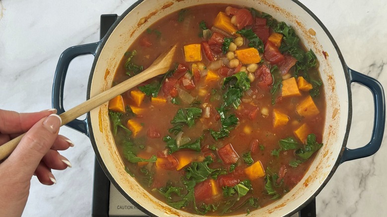 stirring kale into stew