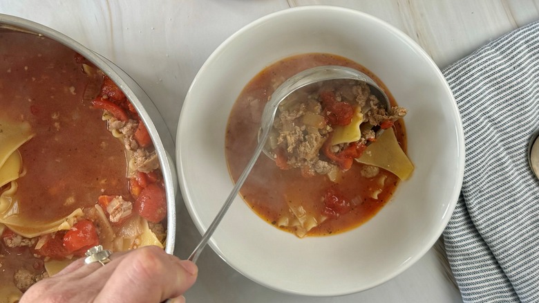 hand ladling soup into bowl