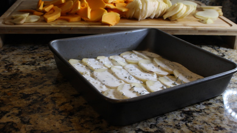 baking dish with sliced potatoes and cream