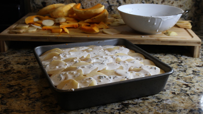 Baking dish filled with sliced potatoes and pumpkin